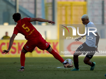 In Ta' Qali, Malta, on September 14, 2024, Alex Bruno de Souza Silva (R) of Hibernians competes for the ball with Augustin Sandona (L) of Bi...