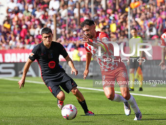 Ivan Martin of Girona challenges Pedri of FC Barcelona for possession during the La Liga EA SPORTS match at Estadi Montilivi in Girona, Spai...