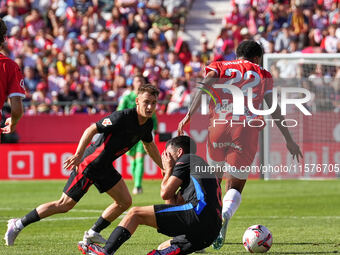 Jhon Solis of Girona challenges Pedri of FC Barcelona for possession during the La Liga EA SPORTS match at Estadi Montilivi in Girona, Spain...