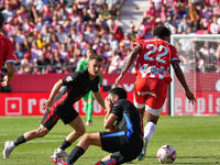 Jhon Solis of Girona challenges Pedri of FC Barcelona for possession during the La Liga EA SPORTS match at Estadi Montilivi in Girona, Spain...