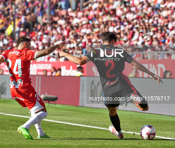 Portu of Girona challenges Pau Cubarsi of FC Barcelona for possession during the La Liga EA SPORTS match at Estadi Montilivi in Girona, Spai...