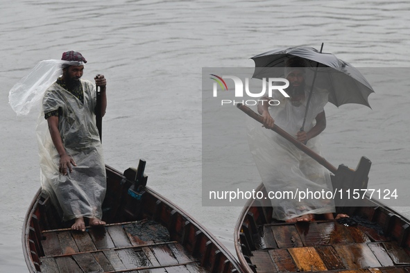 Boatmen wait for passengers during a drizzle at the Buriganga River in Dhaka, Bangladesh, on September 15, 2024. 