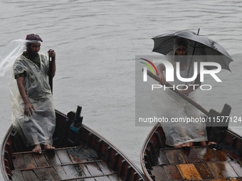 Boatmen wait for passengers during a drizzle at the Buriganga River in Dhaka, Bangladesh, on September 15, 2024. (