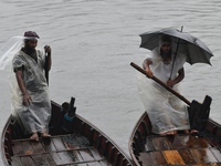 Boatmen wait for passengers during a drizzle at the Buriganga River in Dhaka, Bangladesh, on September 15, 2024. (