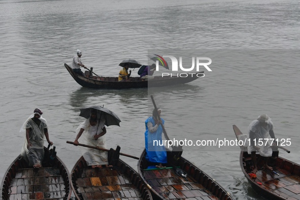 Passengers cross the Buriganga River, holding umbrellas during a drizzle in Dhaka, Bangladesh, on September 15, 2024. 