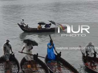 Passengers cross the Buriganga River, holding umbrellas during a drizzle in Dhaka, Bangladesh, on September 15, 2024. (