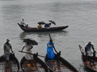 Passengers cross the Buriganga River, holding umbrellas during a drizzle in Dhaka, Bangladesh, on September 15, 2024. (