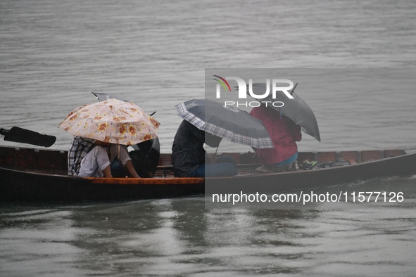 Passengers cross the Buriganga River, holding umbrellas during a drizzle in Dhaka, Bangladesh, on September 15, 2024. 