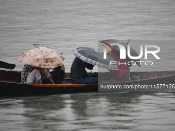 Passengers cross the Buriganga River, holding umbrellas during a drizzle in Dhaka, Bangladesh, on September 15, 2024. (