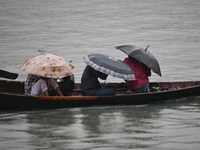 Passengers cross the Buriganga River, holding umbrellas during a drizzle in Dhaka, Bangladesh, on September 15, 2024. (