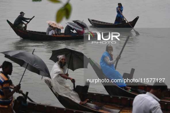 Passengers cross the Buriganga River, holding umbrellas during a drizzle in Dhaka, Bangladesh, on September 15, 2024. 