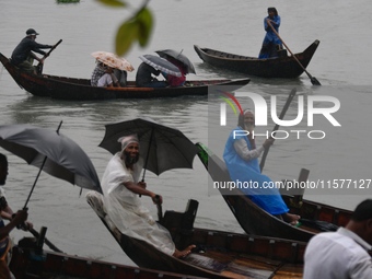 Passengers cross the Buriganga River, holding umbrellas during a drizzle in Dhaka, Bangladesh, on September 15, 2024. (