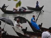 Passengers cross the Buriganga River, holding umbrellas during a drizzle in Dhaka, Bangladesh, on September 15, 2024. (