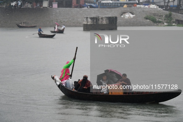 Passengers cross the Buriganga River, holding umbrellas during a drizzle in Dhaka, Bangladesh, on September 15, 2024. 