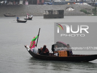 Passengers cross the Buriganga River, holding umbrellas during a drizzle in Dhaka, Bangladesh, on September 15, 2024. (