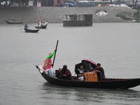 Passengers cross the Buriganga River, holding umbrellas during a drizzle in Dhaka, Bangladesh, on September 15, 2024. (