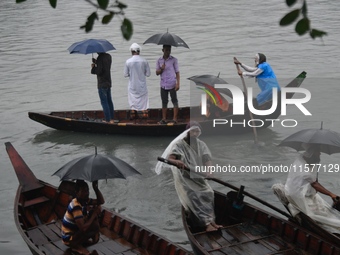 Passengers cross the Buriganga River, holding umbrellas during a drizzle in Dhaka, Bangladesh, on September 15, 2024. (