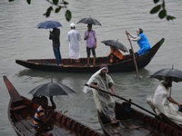 Passengers cross the Buriganga River, holding umbrellas during a drizzle in Dhaka, Bangladesh, on September 15, 2024. (