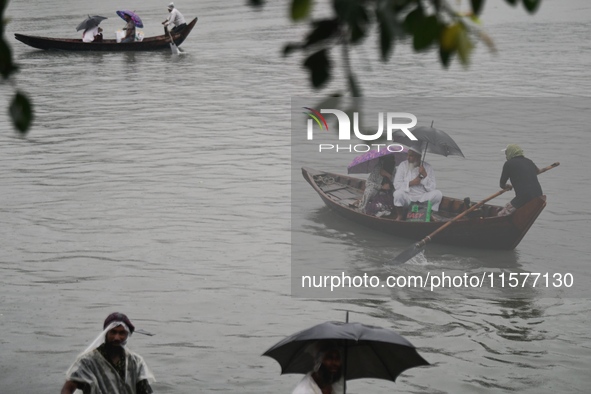 Passengers cross the Buriganga River, holding umbrellas during a drizzle in Dhaka, Bangladesh, on September 15, 2024. 