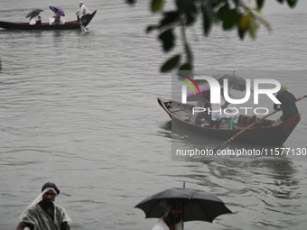 Passengers cross the Buriganga River, holding umbrellas during a drizzle in Dhaka, Bangladesh, on September 15, 2024. (