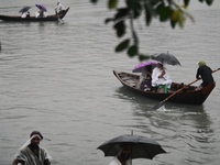 Passengers cross the Buriganga River, holding umbrellas during a drizzle in Dhaka, Bangladesh, on September 15, 2024. (