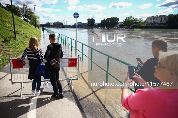 People watch a flood-wave peak after heavy rainfall  rised  the level of the Vistula River flooding a part of the boulvards in Krakow, Polan...