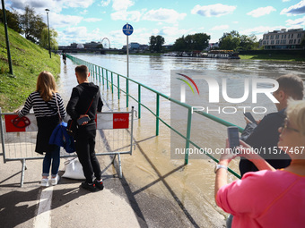 People watch a flood-wave peak after heavy rainfall  rised  the level of the Vistula River flooding a part of the boulvards in Krakow, Polan...