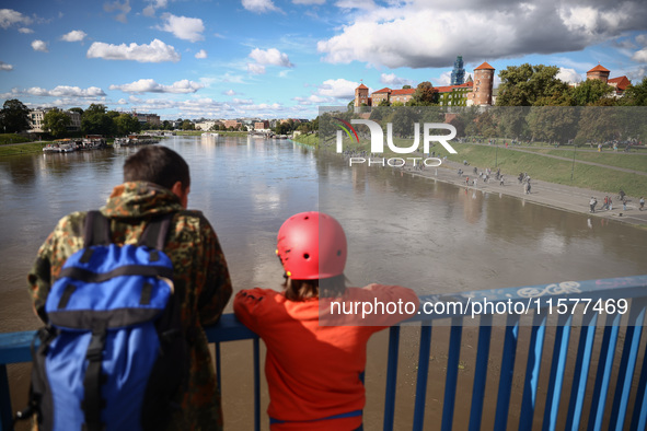 People watch a flood-wave peak after heavy rainfall  rised  the level of the Vistula River flooding a part of the boulvards in Krakow, Polan...