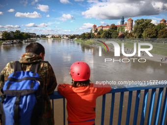 People watch a flood-wave peak after heavy rainfall  rised  the level of the Vistula River flooding a part of the boulvards in Krakow, Polan...