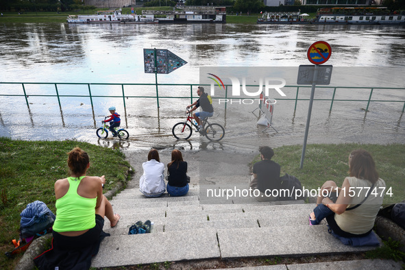 People watch a flood-wave peak after heavy rainfall  rised  the level of the Vistula River flooding a part of the boulvards in Krakow, Polan...