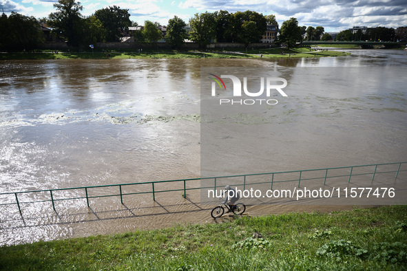 A person rides a bike after heavy rainfall rised the level of the Vistula River flooding a part of the boulvards in Krakow, Poland on Septem...