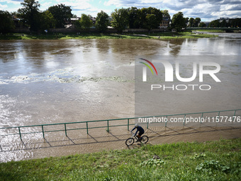 A person rides a bike after heavy rainfall rised the level of the Vistula River flooding a part of the boulvards in Krakow, Poland on Septem...