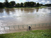 A person rides a bike after heavy rainfall rised the level of the Vistula River flooding a part of the boulvards in Krakow, Poland on Septem...