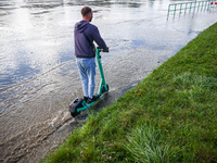 A person rides electric scooter after heavy rainfall raised  the level of the Vistula River flooding a part of the boulvards in Krakow, Pola...