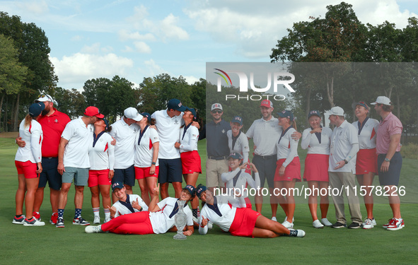 GAINESVILLE, VIRGINIA - SEPTEMBER 15: Team USA poses with their spouses and partners on the 18th green after winning the cup for the United...