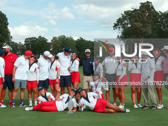 GAINESVILLE, VIRGINIA - SEPTEMBER 15: Team USA poses with their spouses and partners on the 18th green after winning the cup for the United...