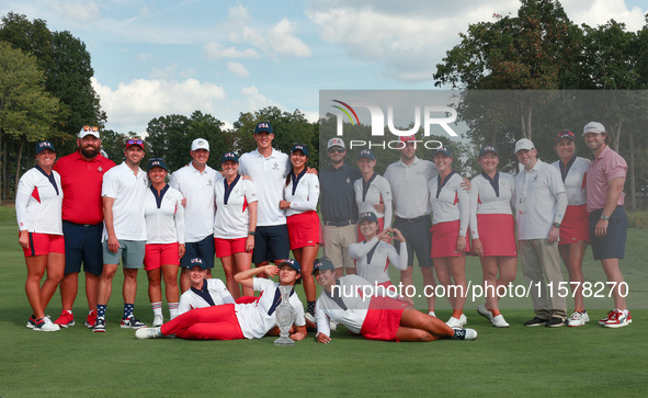 GAINESVILLE, VIRGINIA - SEPTEMBER 15: Team USA poses with their spouses and partners on the 18th green after winning the cup for the United...