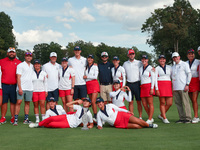 GAINESVILLE, VIRGINIA - SEPTEMBER 15: Team USA poses with their spouses and partners on the 18th green after winning the cup for the United...