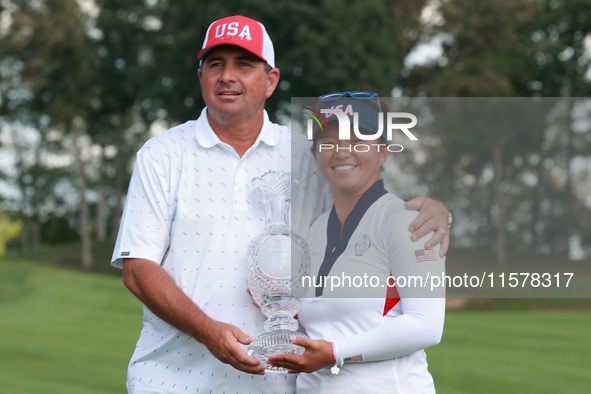 GAINESVILLE, VIRGINIA - SEPTEMBER 15: Megan Khang of the United States poses with her caddie, holding the trophy on the 18th green at the co...