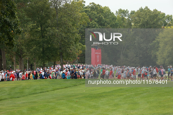 GAINESVILLE, VIRGINIA - SEPTEMBER 15: Fans cross the fairway of the seventh hole during single matches on Day Three of the Solheim Cup at Ro...