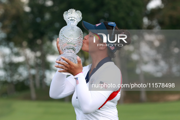 GAINESVILLE, VIRGINIA - SEPTEMBER 15: Megan Khang of the United States kisses the trophy on the 18th green at the conclusion of the Solheim...