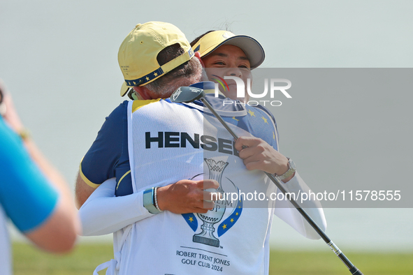 GAINESVILLE, VIRGINIA - SEPTEMBER 15: Celine Boutier of Team Europe celebrates her putt on the 18th green with her caddie during single matc...