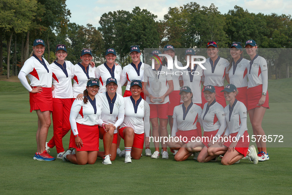 GAINESVILLE, VIRGINIA - SEPTEMBER 15: Team USA poses with the trophy on the 18th green at the conclusion  of the Solheim Cup at Robert Trent...