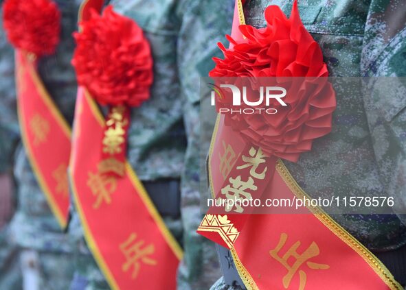 New recruits wearing red flowers attend a send-off ceremony at the Yongnian district militia training base in Handan, China, on September 14...