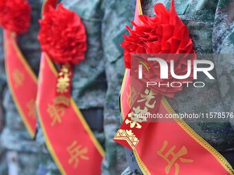 New recruits wearing red flowers attend a send-off ceremony at the Yongnian district militia training base in Handan, China, on September 14...