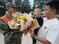 A child presents flowers to new recruits at the militia training base in Yongnian district of Handan, China, on September 14, 2024. (