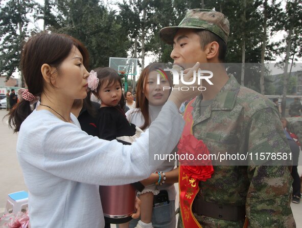 A new recruit tastes dumplings made by his family at the militia training base in Yongnian district of Handan, in Handan, China, on Septembe...