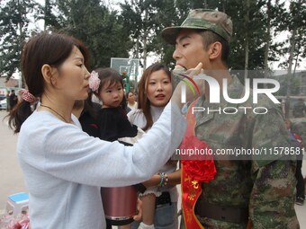 A new recruit tastes dumplings made by his family at the militia training base in Yongnian district of Handan, in Handan, China, on Septembe...