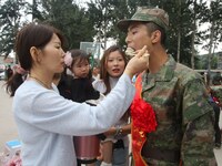 A new recruit tastes dumplings made by his family at the militia training base in Yongnian district of Handan, in Handan, China, on Septembe...