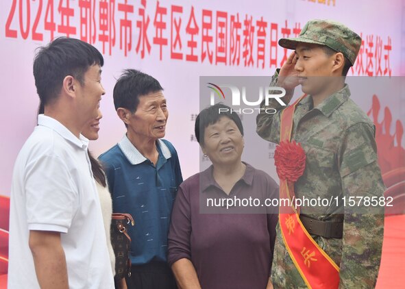 A new recruit salutes his family at a militia training base in Yongnian district of Handan, China, on September 14, 2024. 